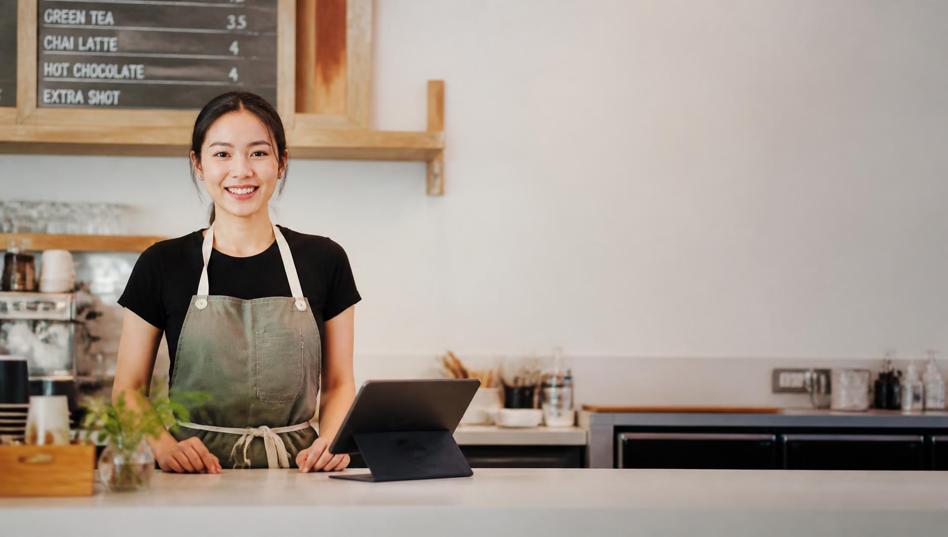 Smiling merchant using Wonder at their counter