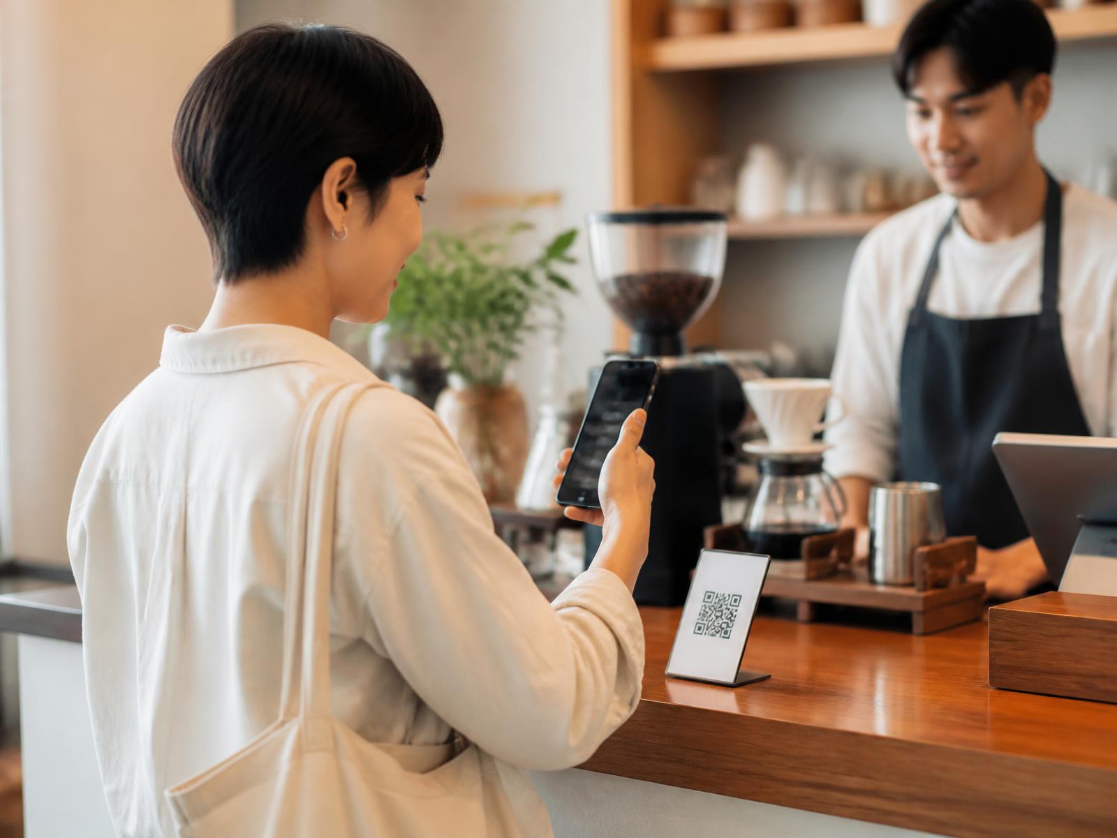 客戶在咖啡店櫃檯掃描 QR 碼